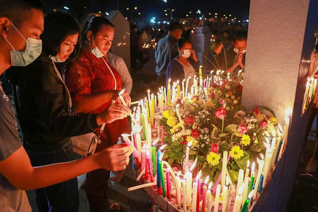 Des fidèles thaïlandais déposent des bougies au cimetière de Tha Rae (province de Sakon Nakhon, dans le nord-est de la Thaïlande).