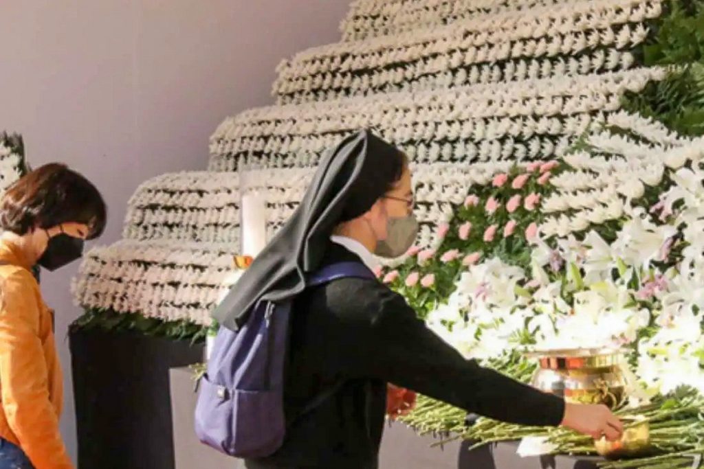 Une religieuse coréenne dépose des fleurs en mémoire des victimes de la bousculade d’Halloween, le 31 octobre 2022 à Séoul.