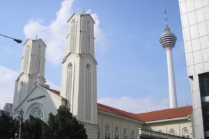 La cathédrale Saint-Jean-l’Évangéliste de Kuala Lumpur, devant la tour Menara Kuala Lumpur ou Tour KL (421 m de haut).