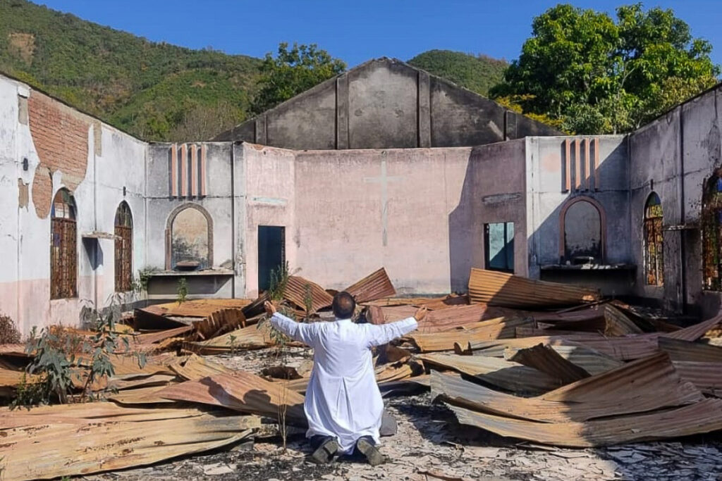Mgr Linus Neli au milieu des ruines de l’église catholique Saint-Joseph de Sugnu, incendiée l’an dernier au Manipur.