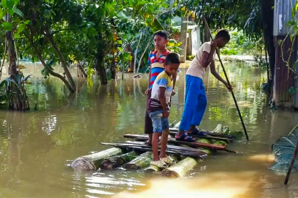 Des enfants utilisent un radeau en bois de bananier dans un village du district de Moulvibazar, le 20 juin dans le nord-est du Bangladesh.