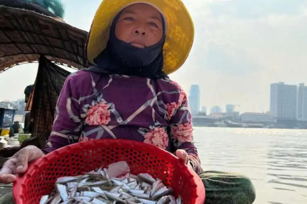 Sao Mas, 64 ans, montre le produit de sa pêche sur le fleuve Mékong, dont elle dépend pour vivre.