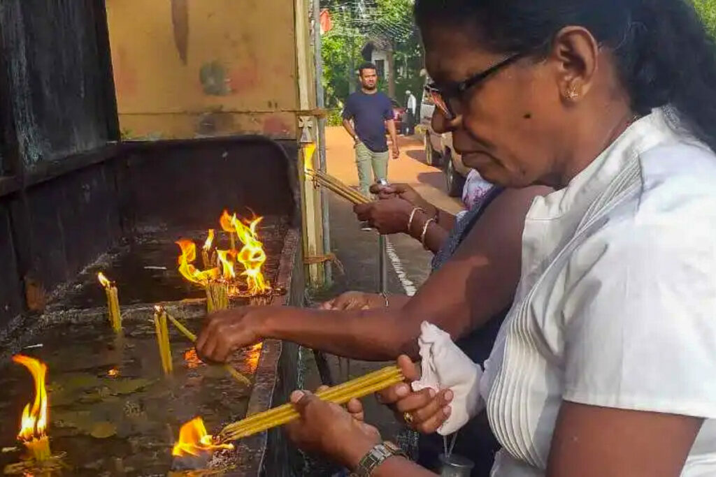 Liyanage Roshani allume des cierges au sanctuaire Saint-Antoine de Kochchikade, au Sri Lanka.