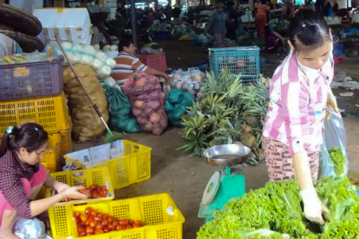 Une ancienne victime de trafic humain (à droite) dans un marché local (juin 2024, province de Thua Thien Hue).