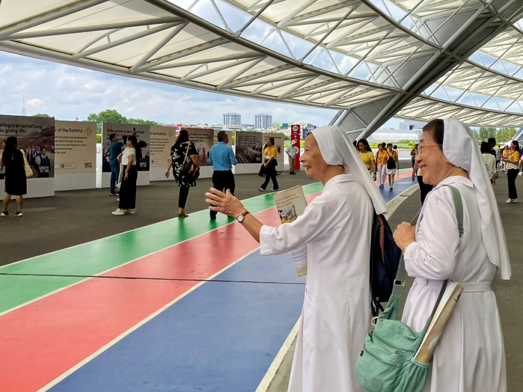 Des religieuses se rendant à leurs places avant la messe, stade national de Singapour.