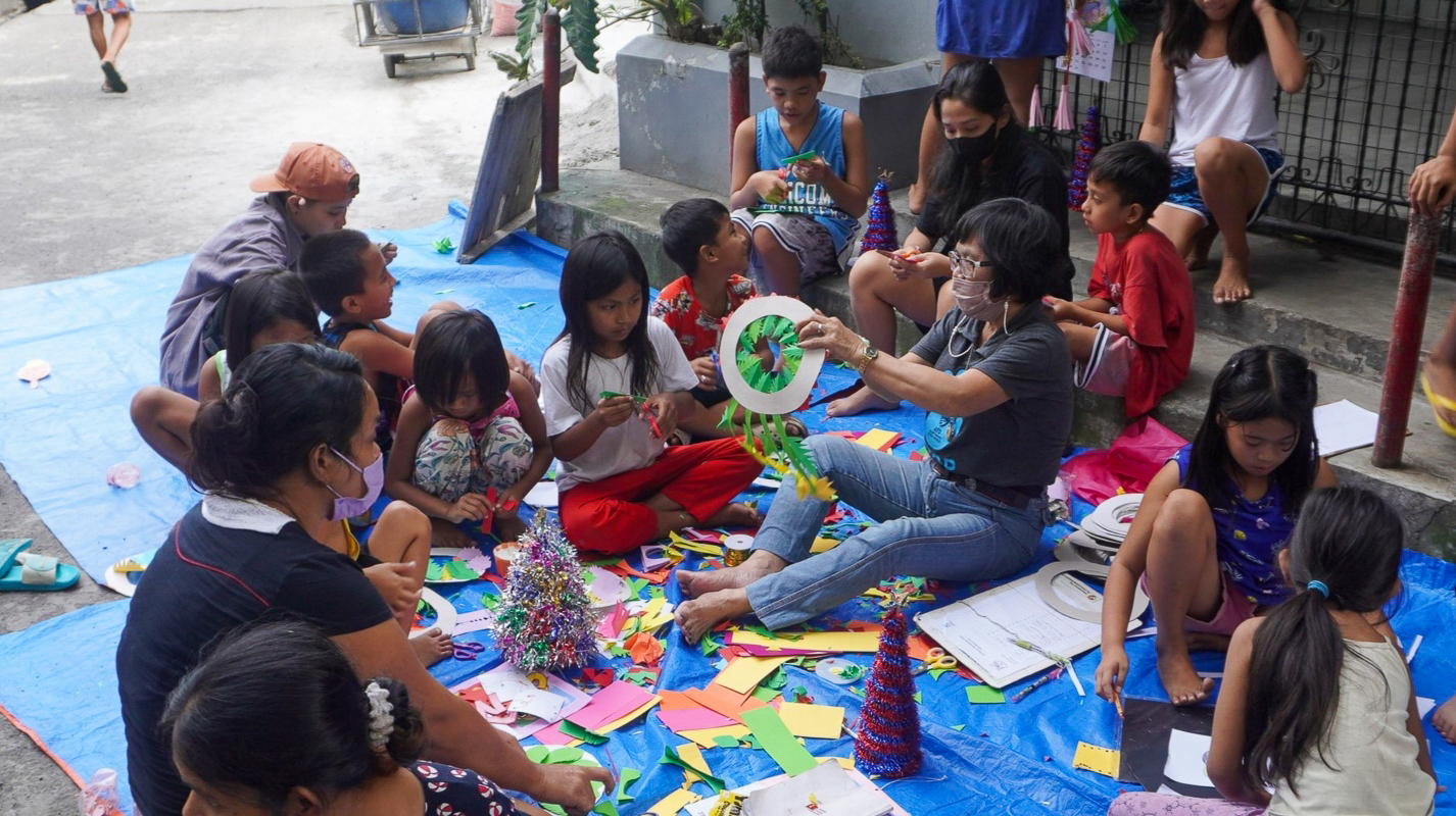 Durant les bibliothèques de rue, les bénévoles et les enfants discutent autour d’un livre ou d’une histoire. Crédit : ATD Quart Monde Philippines