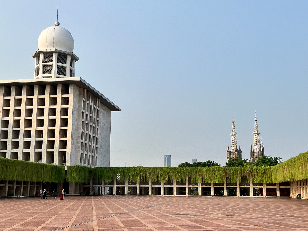 Les flèches de la cathédrale Sainte-Marie de l'Assomption de Jakarta, vues depuis la cour intérieure de la mosquée Istiqlal.