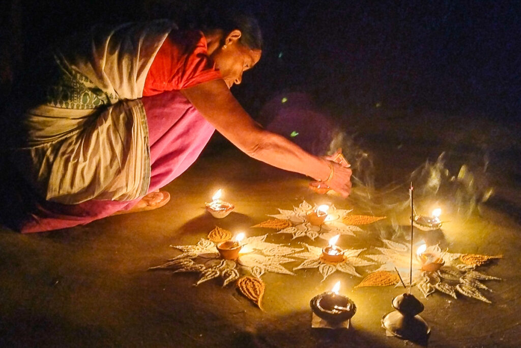 Une femme allumant des lampes à huile durant la fête de Diwali (Assam, Inde).