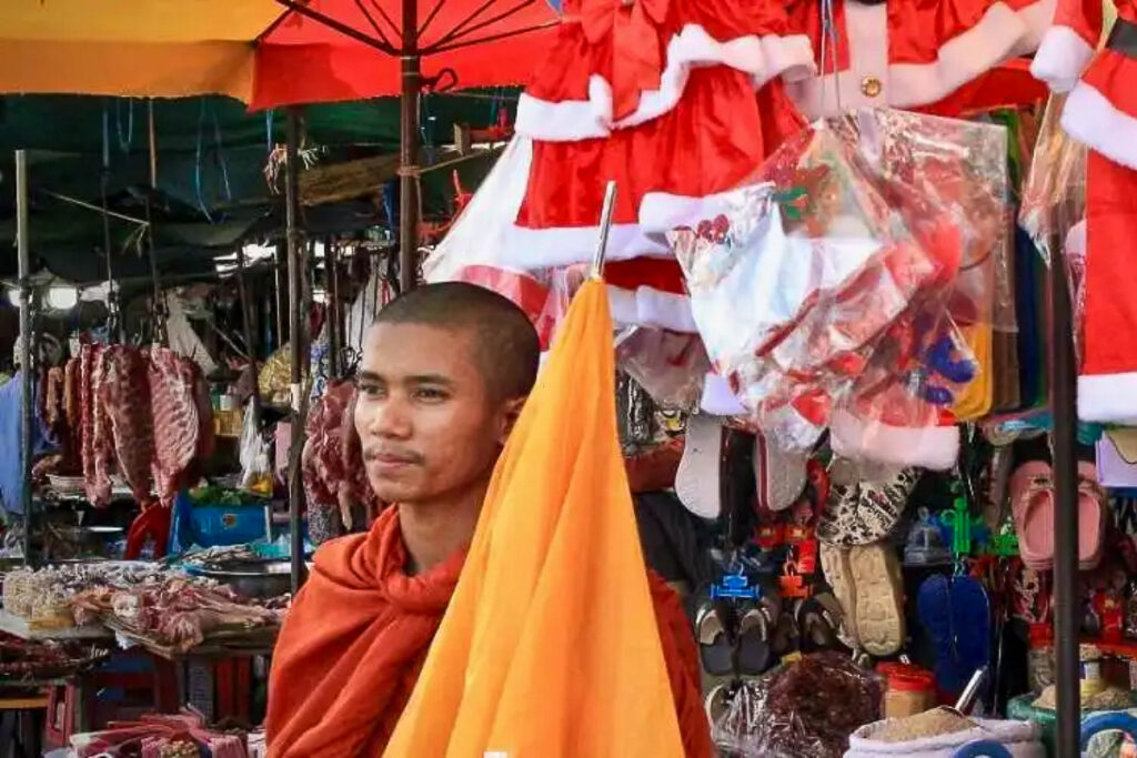 Un moine bouddhiste devant un étal au moment de Noël au marché de Kandal, Phnom Penh.