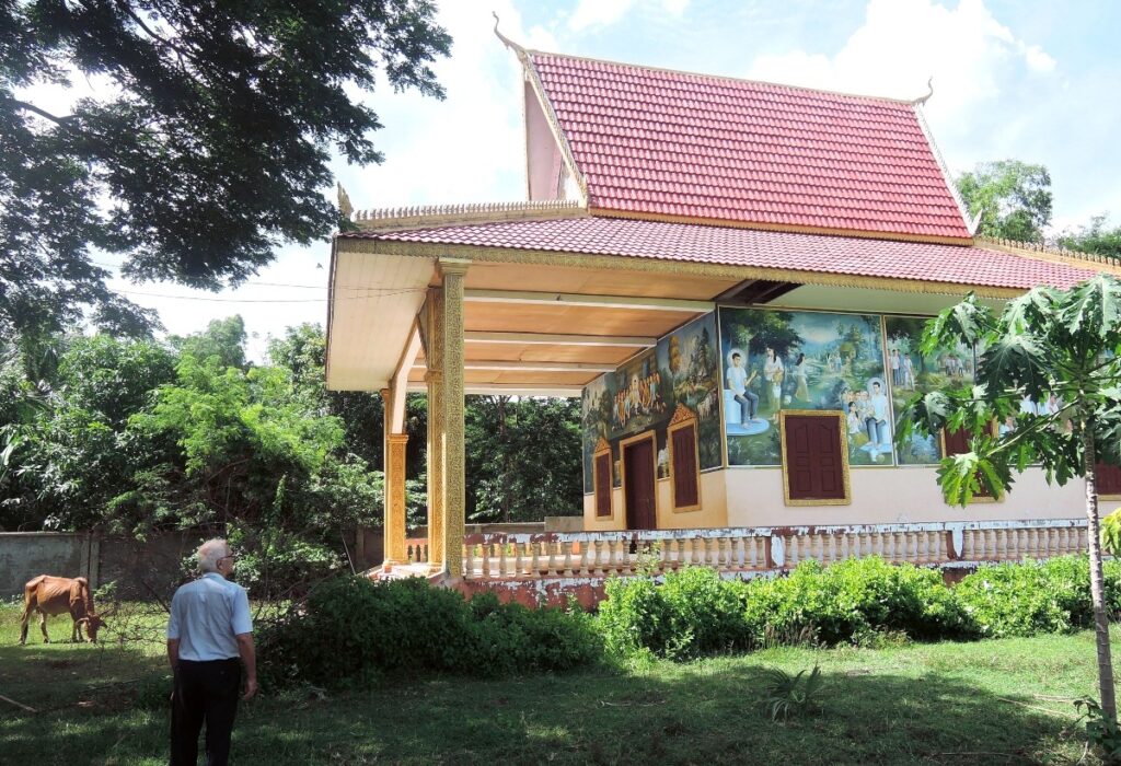 Le père Ponchaud devant l'église de Chamlak qu'il a fait construire, avec des fresques bibliques de style khmer