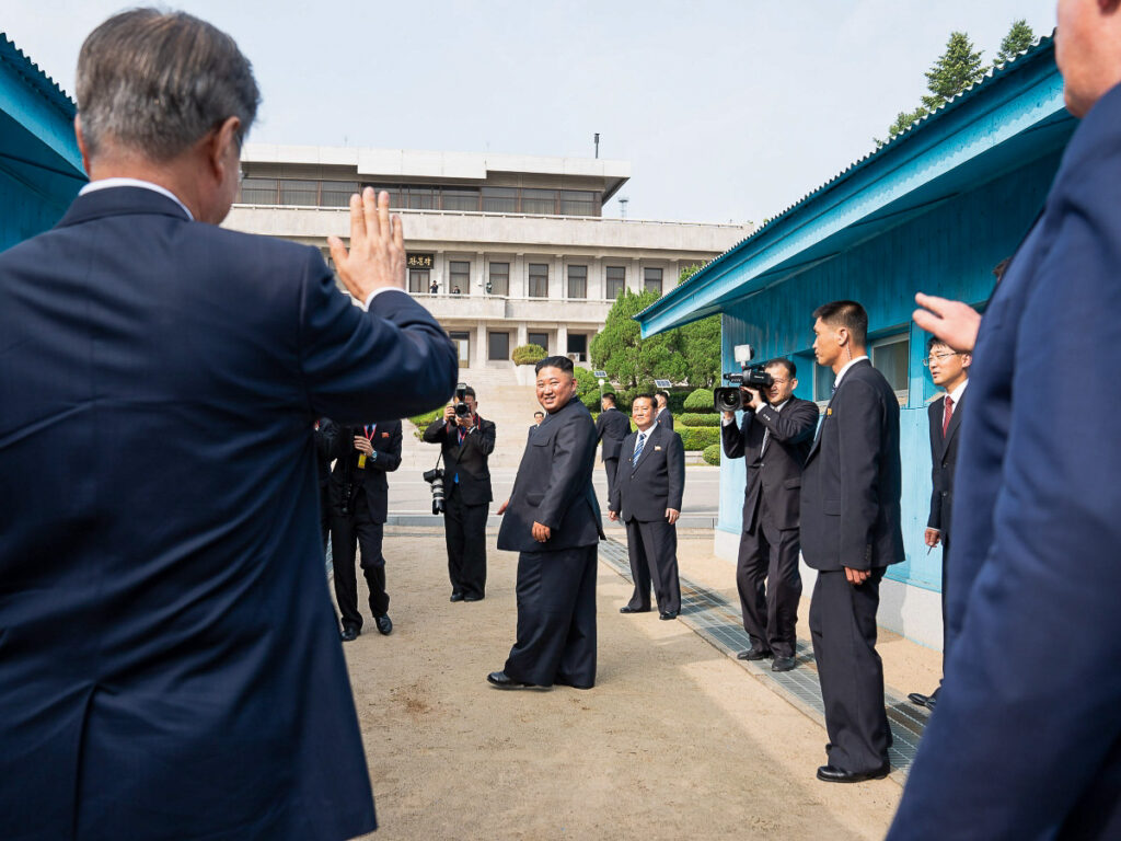L’ex-président sud-coréen Moon Jae-in (2017-2022) et Donald Trump saluent le dirigeant nord-coréen Kim Jong-un lors d’une rencontre à la frontière intercoréenne en 2019.