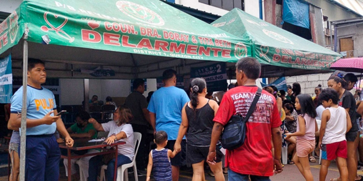 Mission médicale, le 22 octobre 2022, Quezon City, Philippines. La police, sur la gauche, surveille les opérations. Sous la tente mise à disposition par la régie du gouvernement local, on voit une affichette sur laquelle counseling est écrit, et des missionnaires chrétiens prennent en charge la mission médicale.