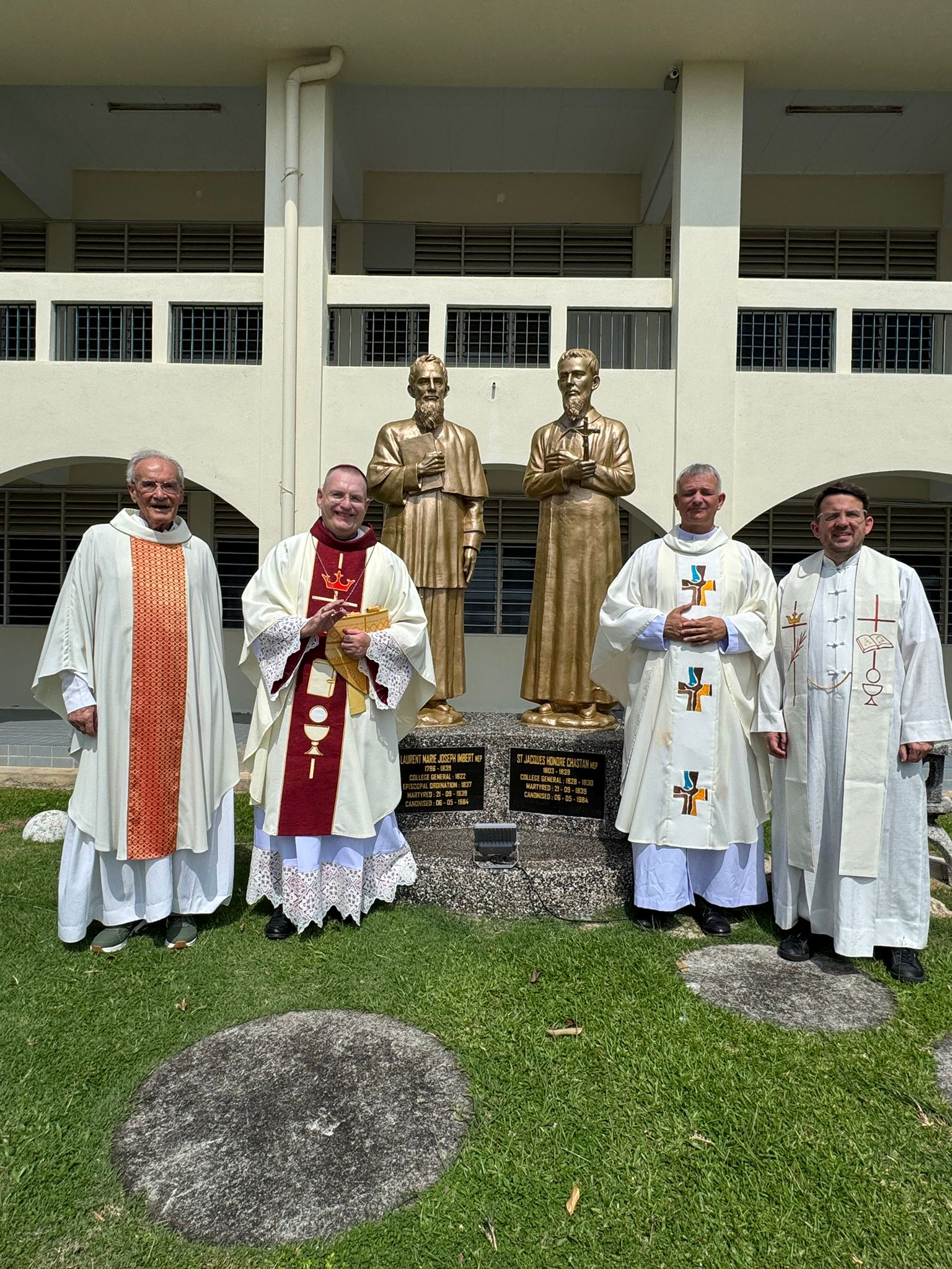 Le P. L'Hour (Mep), Mgr Schmitthaeusler (Mep, vicaire apostolique de Phnom Penh), P. Sénéchal (supérieur général Mep) et P. Frécond (vicaire général Mep) devant les statues des saints Chastan et Imbert (Mep et anciens formateurs du séminaire, martyrs en Corée en 1839).