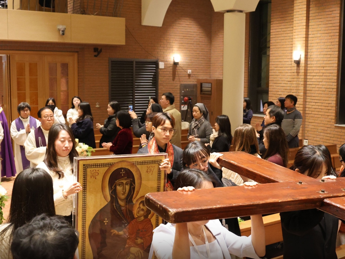 Des pèlerins portant la Croix des JMJ en procession devant l’église de Gahoedong (Séoul), le 28 décembre 2025.