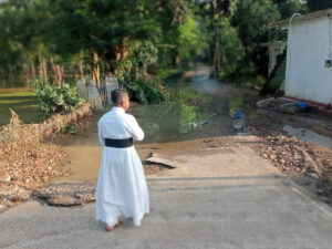 Un prêtre observe les dégâts et les inondations des routes à Anuradhapura, début décembre 2025 au Sri Lanka.