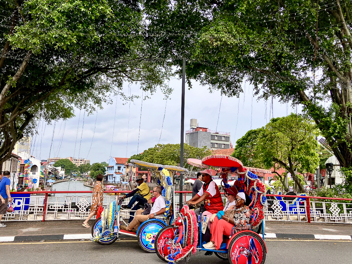 Quelques « rickshaws » aux couleurs vives sur le pont qui franchit la rivière de Malacca, entre le quartier chinois et la place rouge.