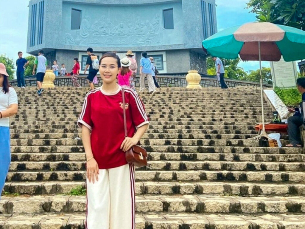 Bui Thi Kim Thanh devant la statue du Christ-Roi de Vung Tau (un monument de 32m de haut situé au sud du Vietnam).