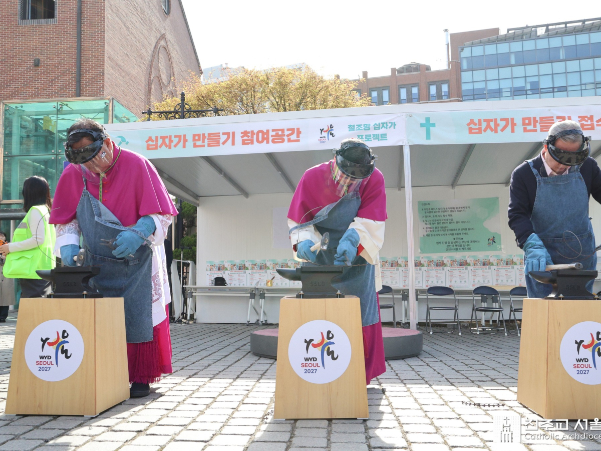 L’archevêque de Séoul et le coordinateur général des JMJ de Séoul 2027 (à gauche) martèlent le fil barbelé lors de l’inauguration du projet.