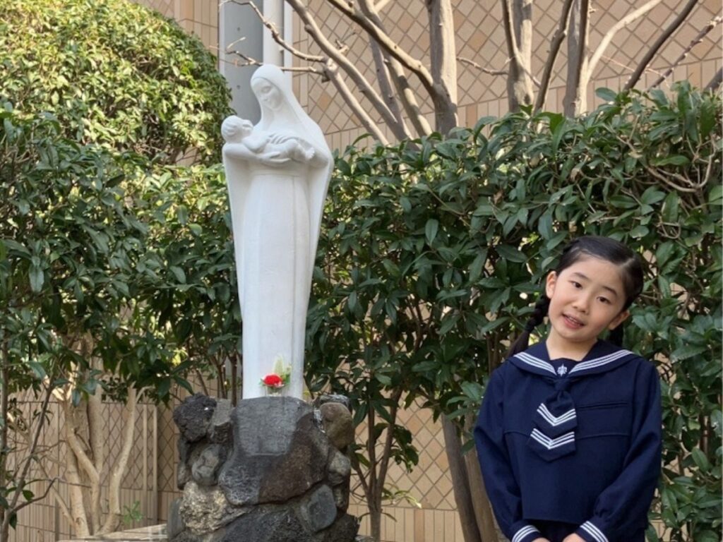 Minami Kimura, 8 ans, devant une statue de la Vierge à l'Enfant devant l'église de Kojimachi (Tokyo).