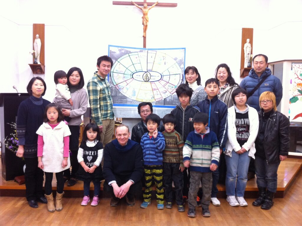 Photo du groupe de catéchisme en 2012 avec le « calendrier liturgique » créé en 1997 et sans cesse amélioré… ici dans sa version en japonais (il existait aussi une version en anglais pour les Philippins, en espagnol pour les Péruviens et en portugais pour les brésiliens)