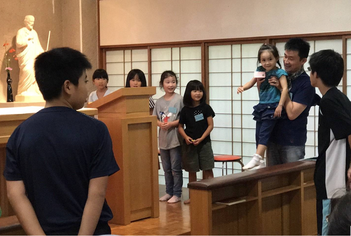 M. Sugiyama, à droite, en train de présenter un enfant lors d’un camp d’été